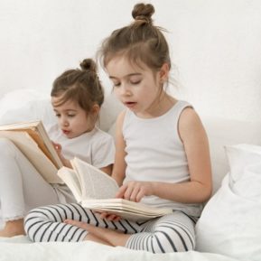 Two young children reading books