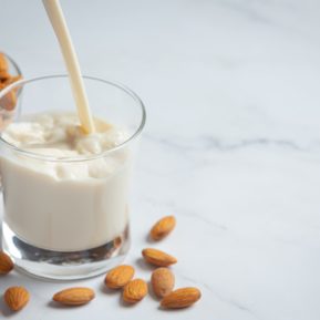 Cup of almond milk with whole almonds