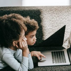 Two children looking at a laptop screen