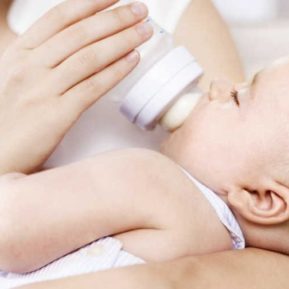 Close up of a baby being fed by a bottle