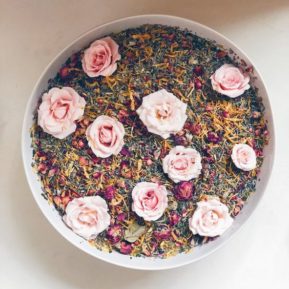 Circular bowl of herbs with pink roses on top