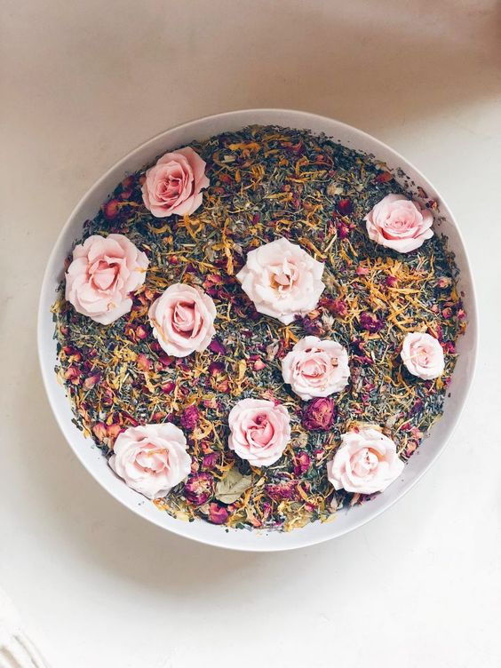Circular bowl of herbs with pink roses on top