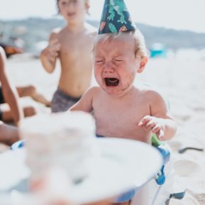 Baby in party hat has a meltdown