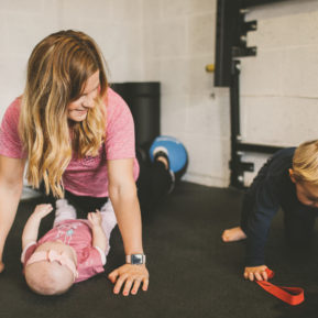Woman performing exercises next to two children