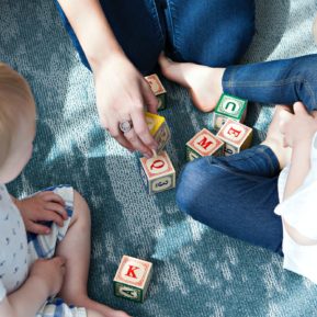 baby and adults playing with blocks