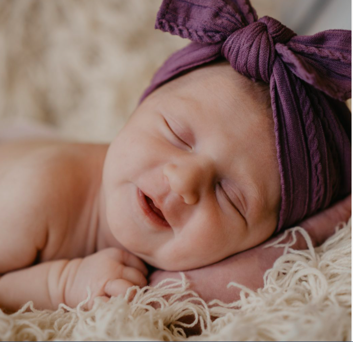 Newborn baby sleeping wearing a headband