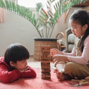 Two young children playing Jenga