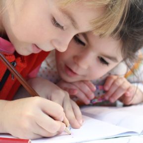 Two preschool children writing together
