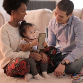 Family with young child looking at a smartphone together