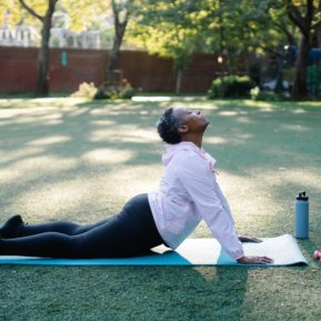 Woman doing yoga on a mat in a garden