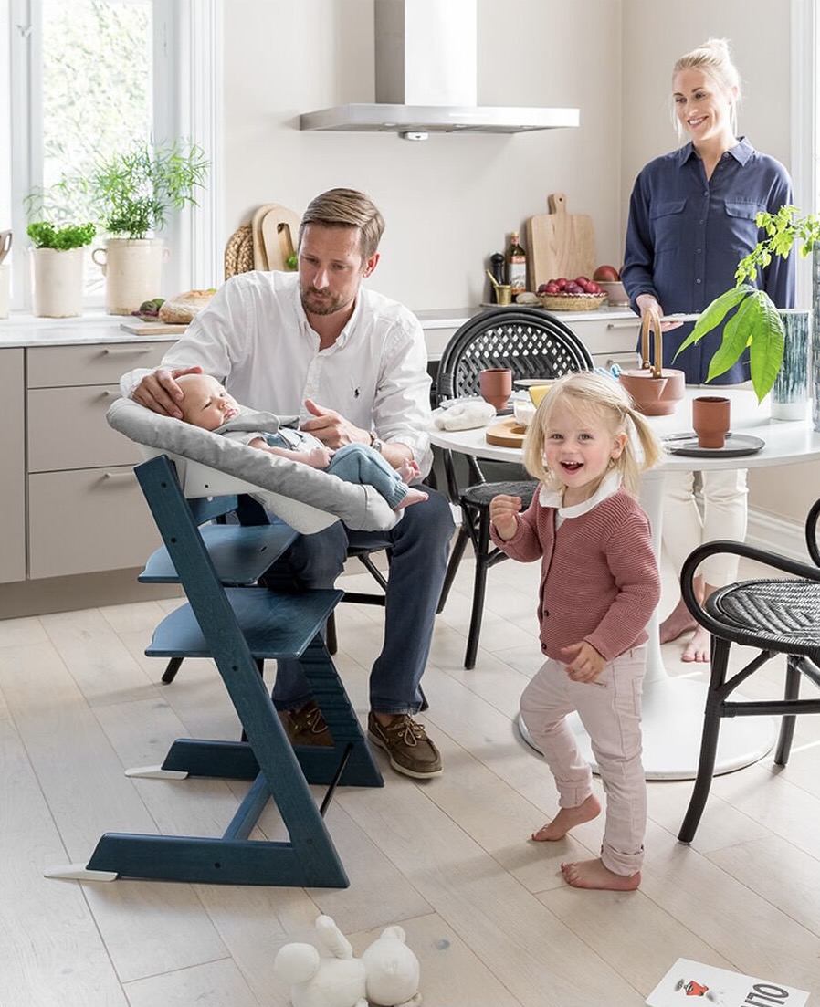 Baby in Stokke highchair with family around table