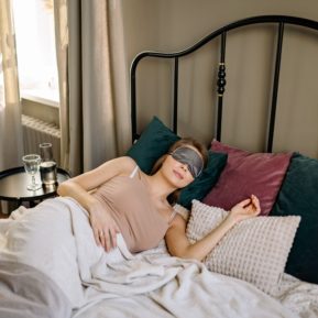 woman sleeping in bed with eye mask