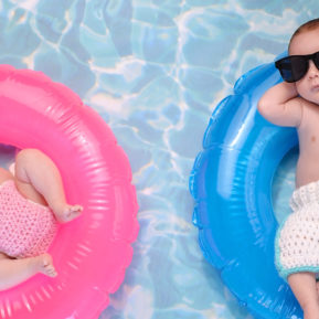 two babies lying on inflatable rings in water