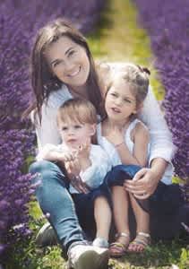 Woman with 2 children surrounded by purple flowers