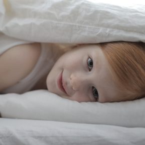 Child awake under the covers