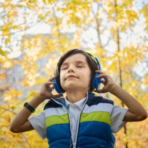 boy wearing headphones in a forest