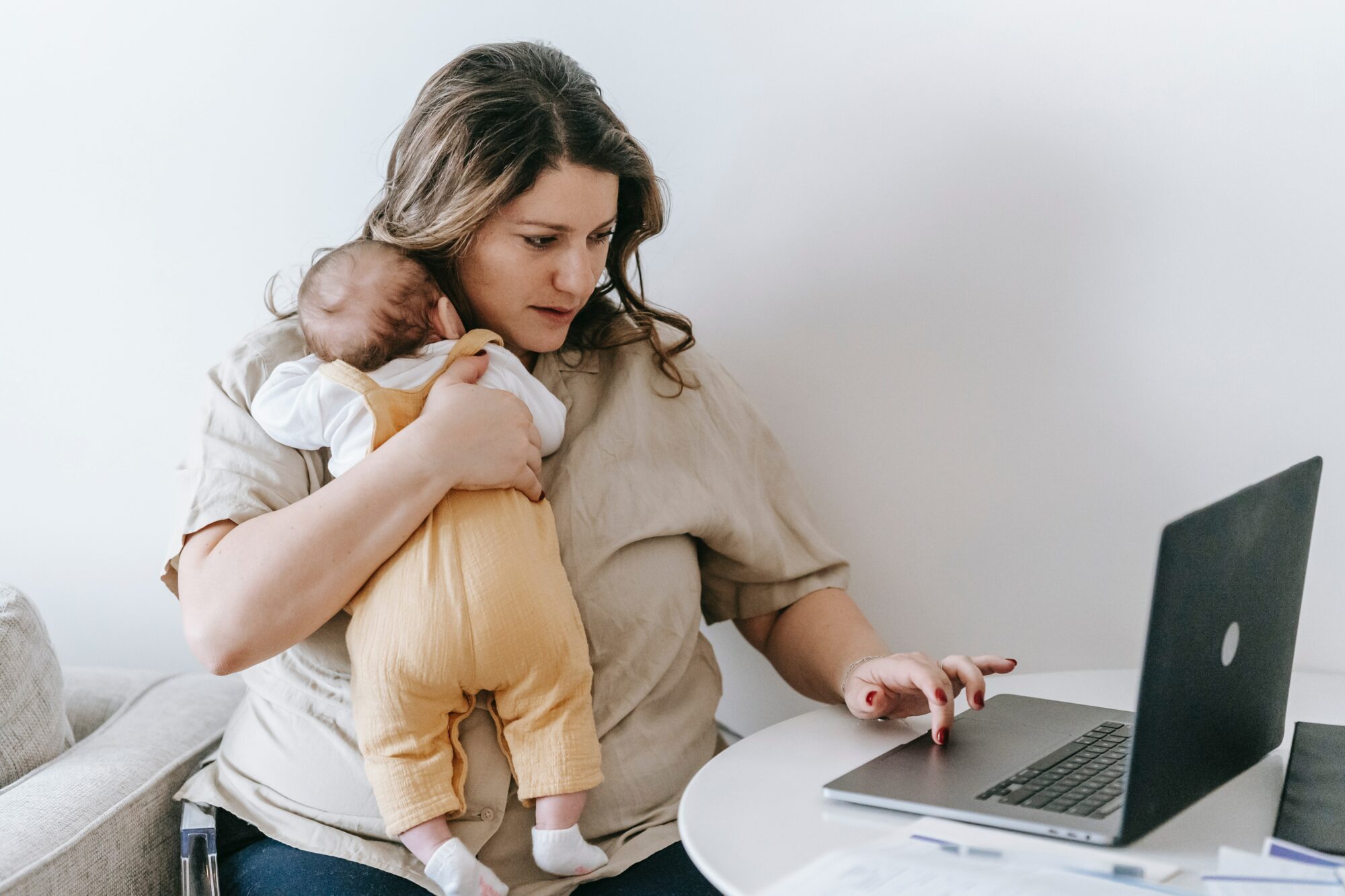 woman working whilst holding a baby