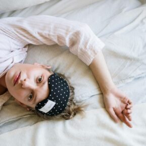 woman with eye mask in bed trying to sleep